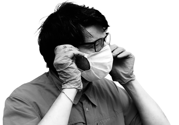 Gözlüklü genç doktor ameliyat maskesi takıyor ve siyah beyaz antika efektler kullanıyor. - Fotoğraf, Görsel