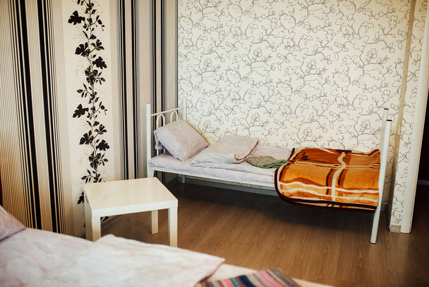 ágynemű a lakásban. dupla kényelmes ágy. minimalista belső tér a lakás élénk színekben. puha, tiszta ágynemű a hotelszobában. éjjeliszekrény és szék - Fotó, kép