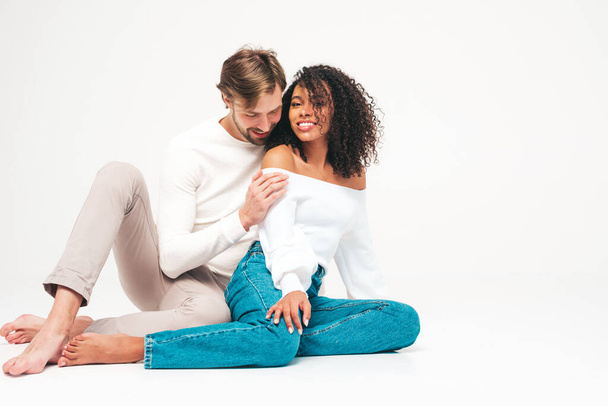 Smiling beautiful woman and her handsome boyfriend. Happy cheerful multiracial family having tender moments on grey background  in studio. Multiethnic models hugging. Embracing each other.Love concept - Photo, image