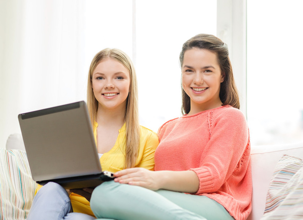 dos chicas adolescentes sonrientes con portátil en casa
 - Foto, imagen