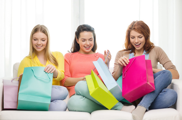 smiling teenage girls with many shopping bags - Foto, imagen