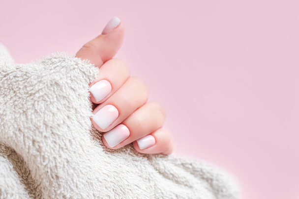 Gradient manicure and Hands Spa. Beautiful Woman hand closeup. Manicured nails and Soft hands skin. Beautiful woman's nails with beautiful baby boomer manicure, pink background. Copy space  - Fotografie, Obrázek