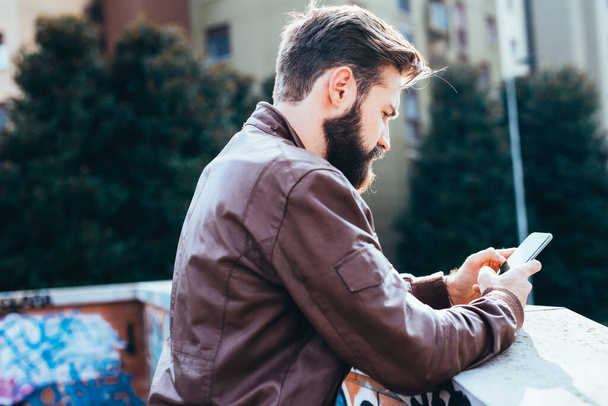 young handsome bearded man using smartphone blogging - Фото, изображение