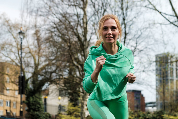 Gesund fitte reife Frau läuft in einem Park in Paddington, London. - Foto, Bild