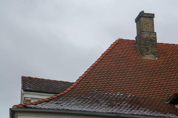 Дах і димар у холодний зимовий день, Копенгаген, Данія. Деталь крутого схилу даху, щоб уникнути накопичення снігу.. - Фото, зображення