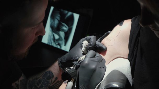 Чоловік робить чорне татуювання змії в студії
 - Фото, зображення