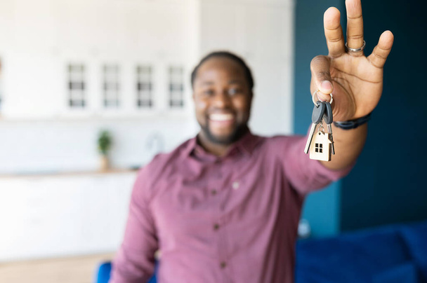 Выборочный фокус на ключах с брелок в виде домика в мужской руке - Фото, изображение