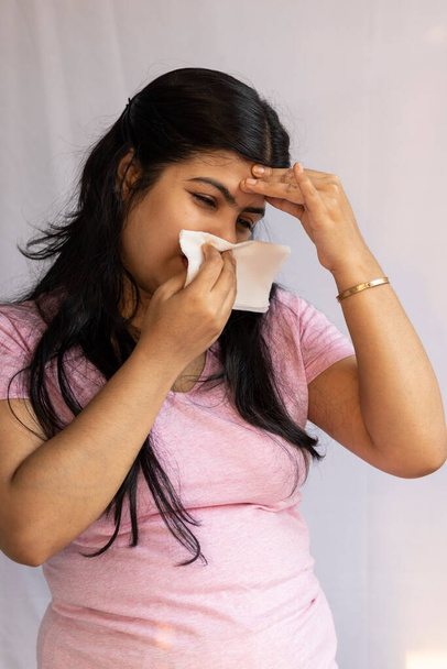 Une femme asiatique indienne souffrant de rhume et de maux de tête montrant un nez qui coule - Photo, image
