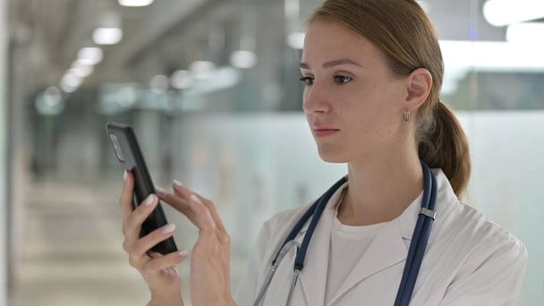 Młoda kobieta lekarz za pomocą smartfona w pracy - Zdjęcie, obraz