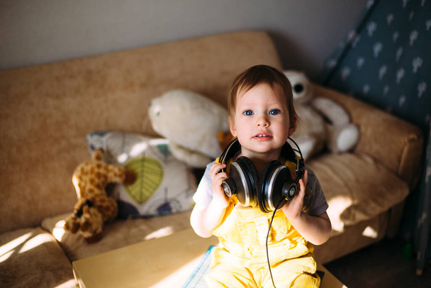 Funny little child having fun with headphones at home, portrait. - Photo, Image