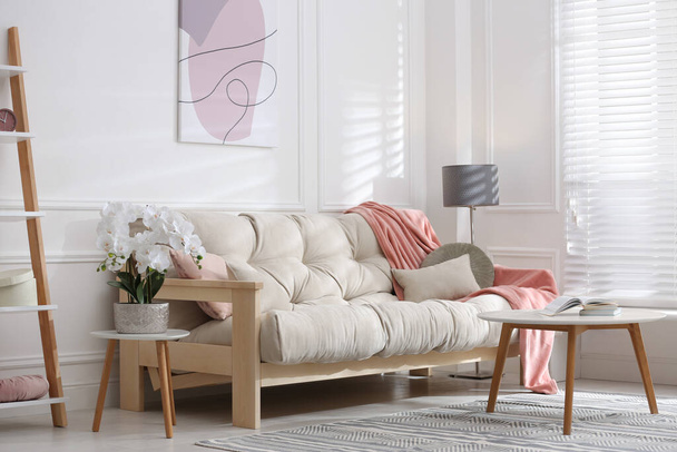 Stylish living room interior with comfortable sofa and beautiful orchid flower - Φωτογραφία, εικόνα