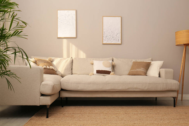 Κομψό εσωτερικό σαλόνι με μοντέρνο άνετο καναπέ και φωτογραφίες - Φωτογραφία, εικόνα