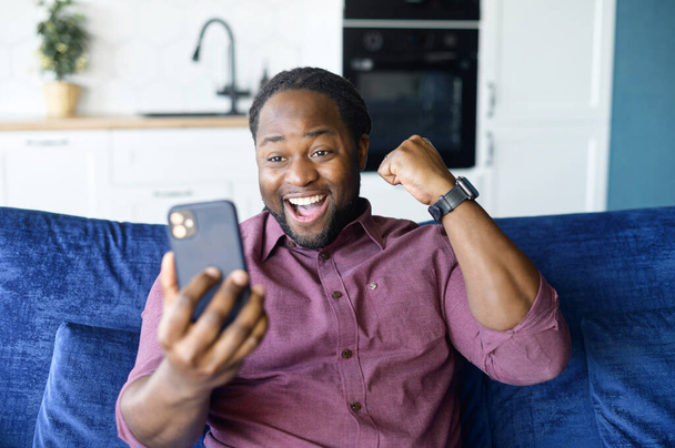Hilarious African-American man celebrating victory - Valokuva, kuva