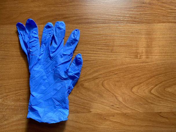 Blaue Latex-Handschuhe auf orangefarbenem Hintergrund. Kopieren Sie den Raum. Sterile Schutzhandschuhe, Medizin - Foto, Bild