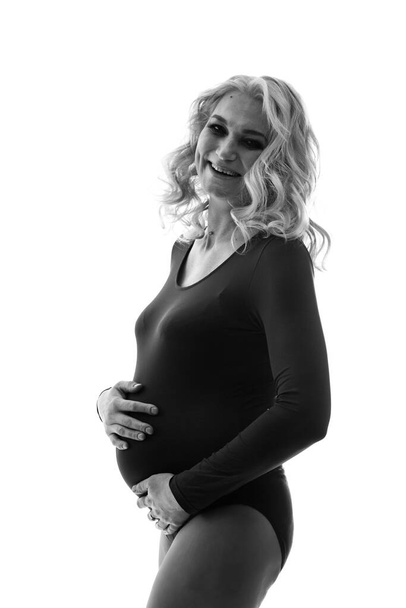 Nuori kaunis raskaana oleva nainen seisoo vaaleanpunainen tausta - Valokuva, kuva