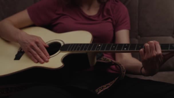 домашние уроки гитары онлайн. женщина играет на гитаре дома на диване. - Кадры, видео