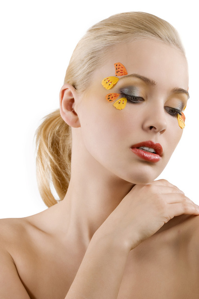 pretty and young blond woman with colored creative make up on white background looking down - Φωτογραφία, εικόνα
