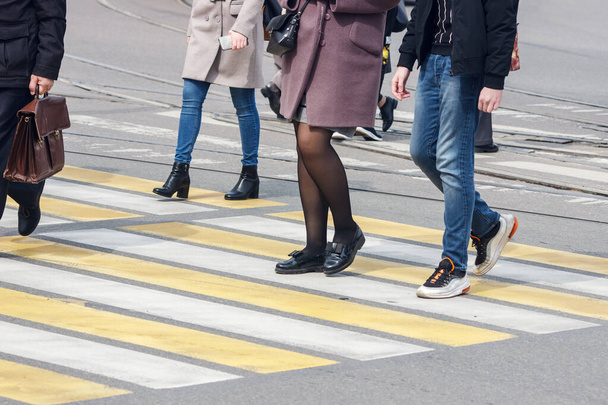 peatones cruzan la calle en un cruce peatonal en el día de primavera - Foto, Imagen