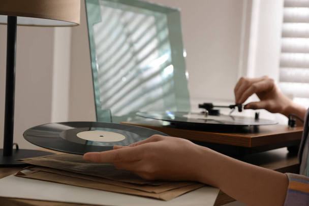 Young woman using turntable at home, closeup - Фото, изображение