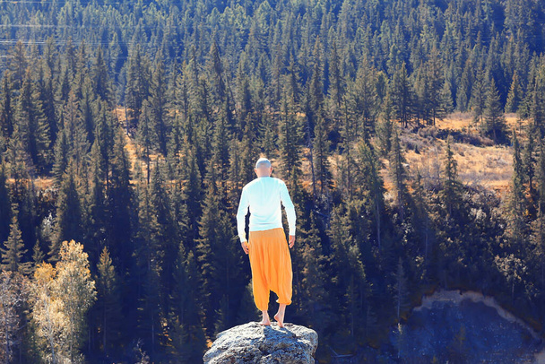 buddhism meditation travel, man doing yoga in traditional yellow pants in nature - Foto, Bild