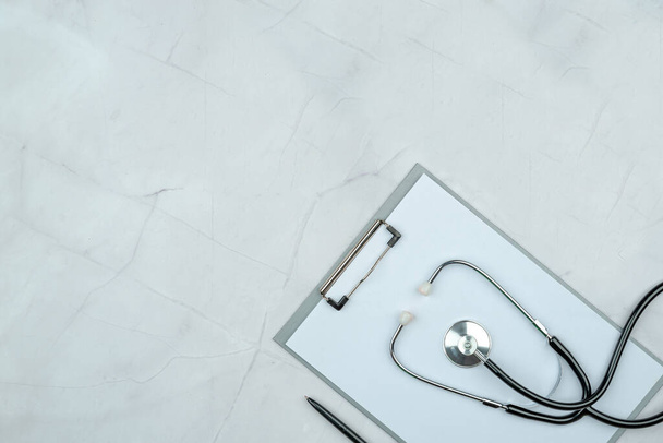 Modern marble work table at the doctor's appointment stethoscope. Purity, white and grey color, flat lay. Empty copy space, clip board - Photo, Image
