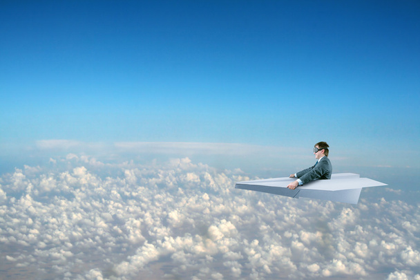 zakenman vliegen op papier vliegtuig - Foto, afbeelding