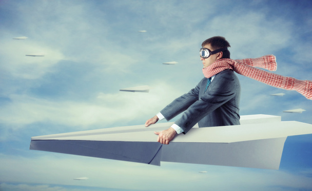 Бизнесмен, летящий на бумажном самолете
 - Фото, изображение