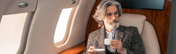 Reifer Mann mit Kaffee im Privatflugzeug, Banner  - Foto, Bild