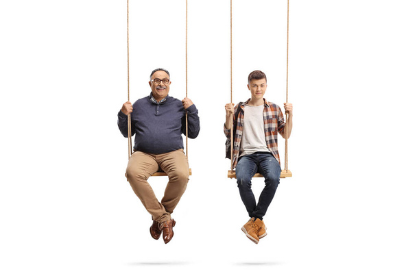 Father and teenage student son sitting on wooden swings isolated on white background - Foto, Bild