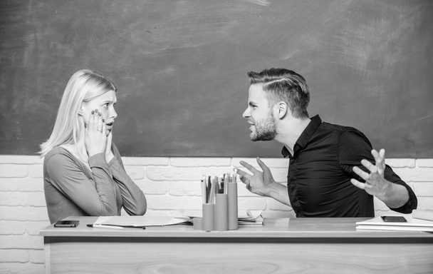Bad news for her. Frustrated teacher and schoolmaster sitting at desk. Handsome man and cute woman back to school. University or college students. High school education. Couple studying in classroom - Foto, Imagem