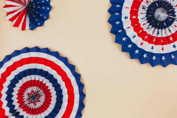 Decoraties voor de 4 juli dag van de Amerikaanse onafhankelijkheid, vlag, kaarsen, rietjes, papier fans. USA vakantie decoraties op een beige achtergrond, bovenaanzicht, platte lay - Foto, afbeelding