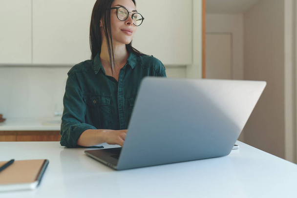 Cropped portrait of business woman working from home with laptop and notebook - Photo, Image