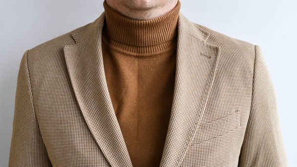Detalle de ropa de hombre, suéter marrón para hombre de moda combinado con chaqueta beige claro. Enfoque selectivo. - Foto, Imagen