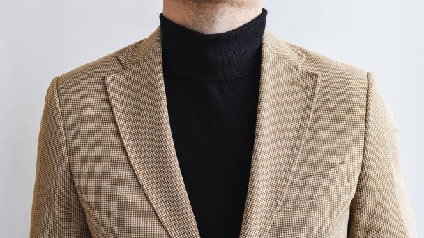 Close up of men outwear, mens black sweater combined with light beige blazer. Selective focus. - Foto, Imagen