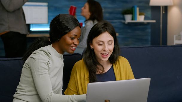 Multiracial friends laughing while watching funny video on laptop - Foto, immagini