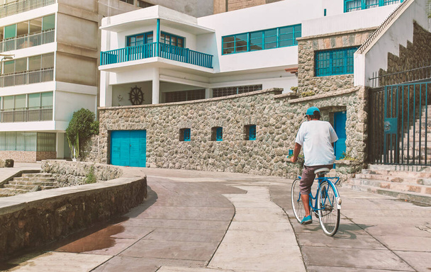 男はアンコン、ペルー、晴れた日の桟橋で大通りのビーチの近くの自転車に乗っています。新常態概念 - 写真・画像
