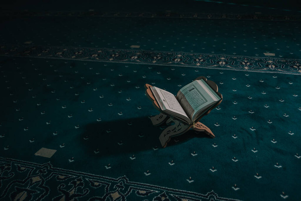 Μουσουλμάνος άνθρωπος προσεύχεται και διαβάζει Κοράνι στο τζαμί - Φωτογραφία, εικόνα