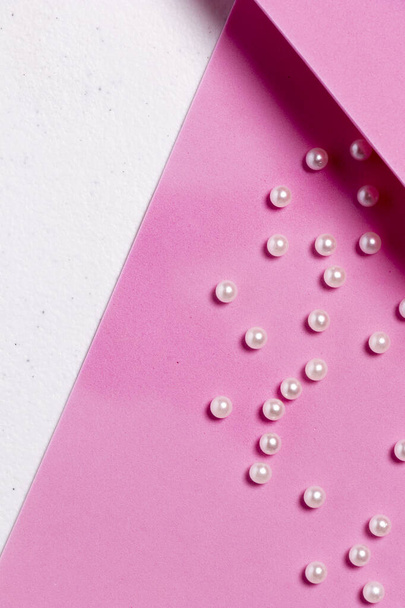 White pearls on pink background as work material to make fashion accessories - Photo, Image