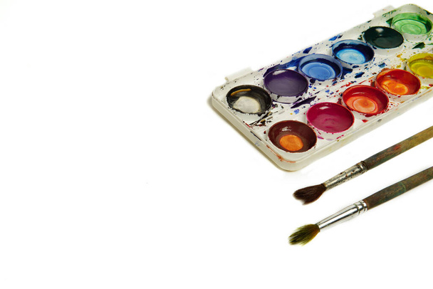 Watercolor paints and brushes, top view. Hobbies and creativity. white background. Set of colorful paints palette. - Zdjęcie, obraz