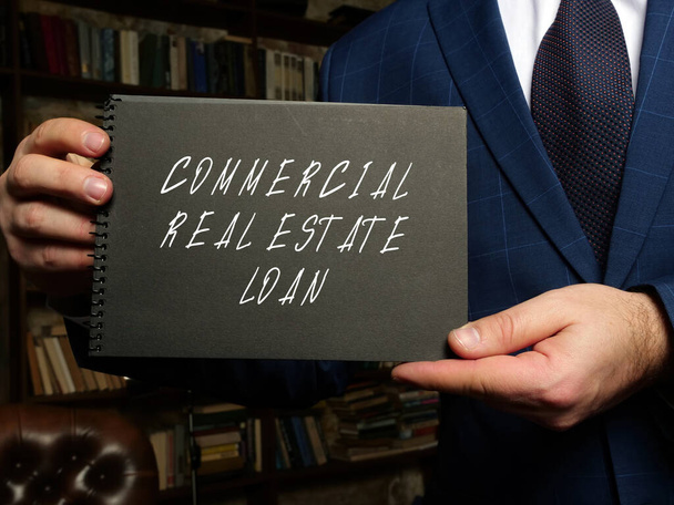 Financial concept meaning COMMERCIAL REAL ESTATE LOAN with phrase on blank notepad in hand. - Photo, Image