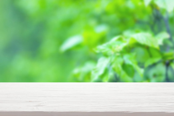 White wood table top on blur green bush background - Фото, зображення
