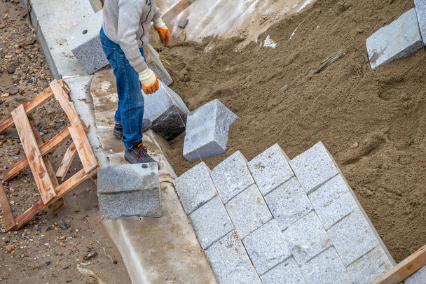 Lavoratore installazione di granito pietra naturale muro per proteggere la riva del fiume da erosione del fiume. - Foto, immagini