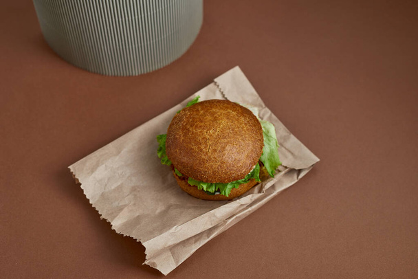 Vegetarian burger on the paper bag on the craft paper concept background - Photo, Image