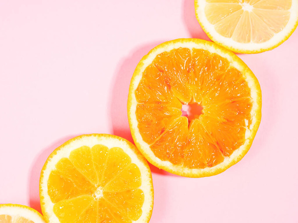 Цитрусовые цветные оранжевый ломтик фруктов текстура фона на пастельно-розовый - Фото, изображение