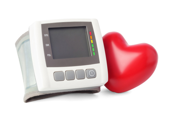 Tensiomètre numérique (tonomètre) et coeur rouge proche, isolé sur fond blanc. - Photo, image