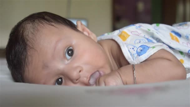 Close-up gezicht van schattige pasgeboren baby jongen rond te kijken terwijl liggend op bed. Drie maanden oud Lieve kleine peuter Closeup portret. Indiaanse etniciteit. Achtergrond van de gezondheidszorg en ontwikkeling voor kinderen. - Video