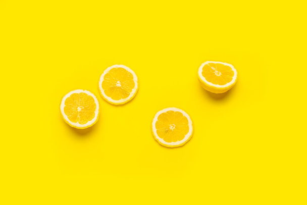 spicchi di limone e limone affettato su fondo giallo. Vista dall'alto, piatta - Foto, immagini