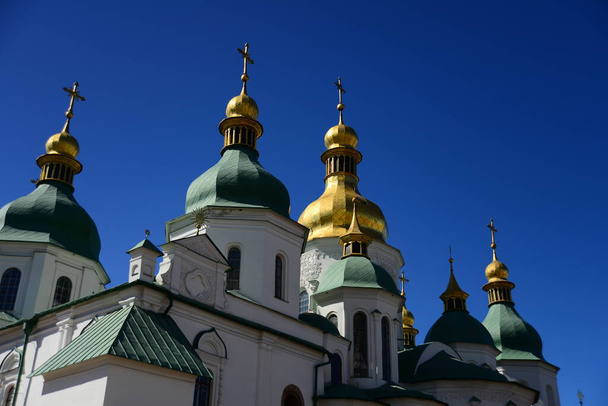 KYIV, UKRAINE - APRIL 5, 2019: Groene en gouden koepels van de kathedraal van St. Sophia in het Sofiivska plein Kiev, Oekraïne - Foto, afbeelding