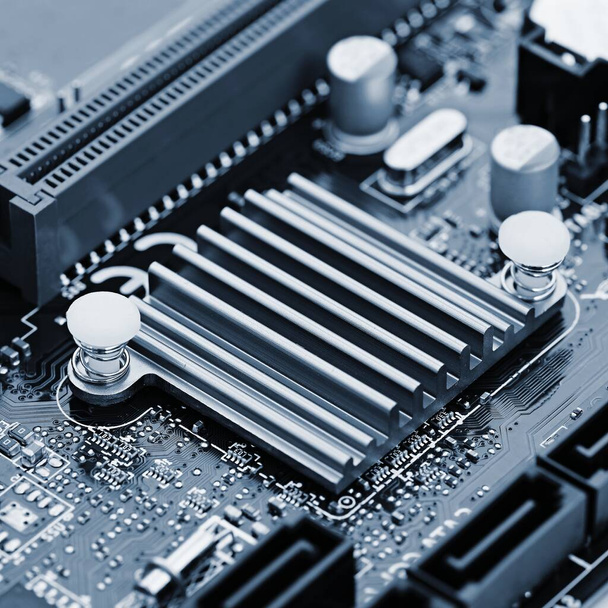 Komponenten an Bord. PCB zu PC. Chip, Kondensator und Anschlüsse auf der Hauptplatine eines PCs. Moderner technischer Hintergrund. - Foto, Bild