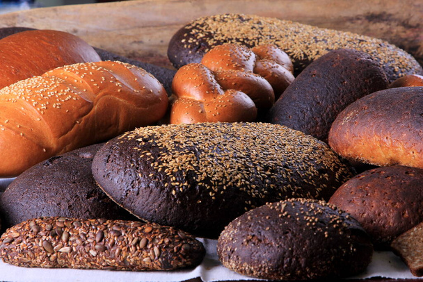 Still life with different types of bread: black, rye, white bread, bread with seeds. bread and wheat ears.  - Photo, Image